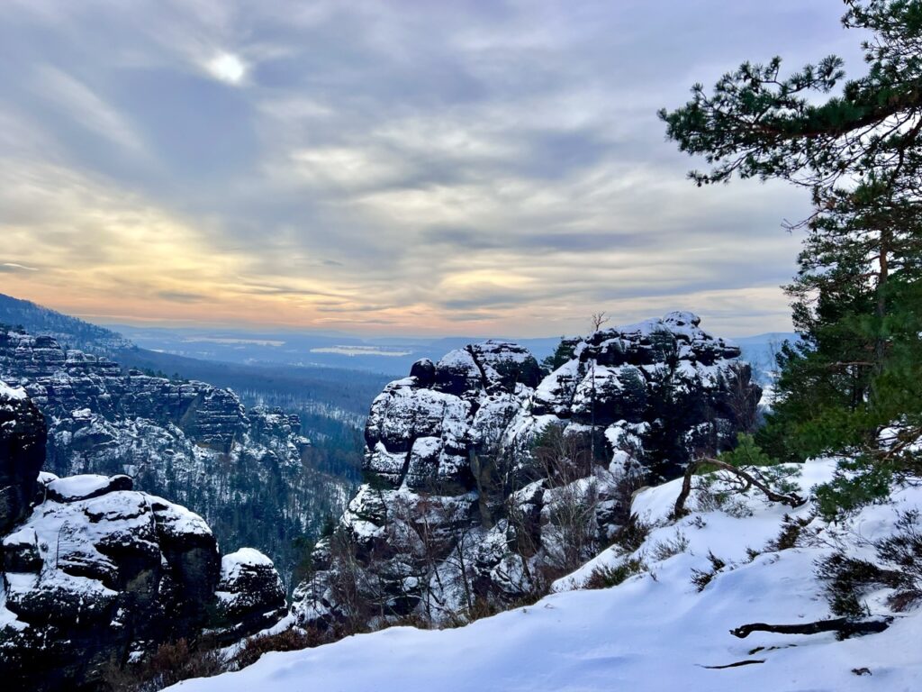 Blick über die verschneite Sächsische Schweiz im Sonnenuntergang